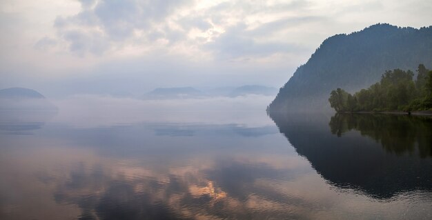 Pintoresco lago de montaña en la mañana brumosa