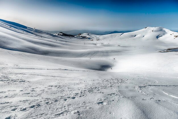 Pintoresco paisaje invernal con montañas cubiertas de nieve, ubicado en Campocatino, ciudad turística de esquí en los Apeninos centrales, Italia