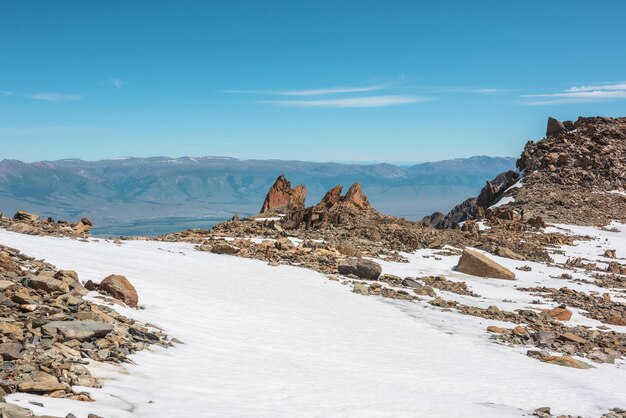 Pintoresco paisaje de montaña con viejas rocas y piedras entre la nieve a la luz del sol Impresionante paisaje alpino con valores atípicos de piedra en alta montaña bajo un cielo azul en un día soleado Rocas afiladas a gran altura