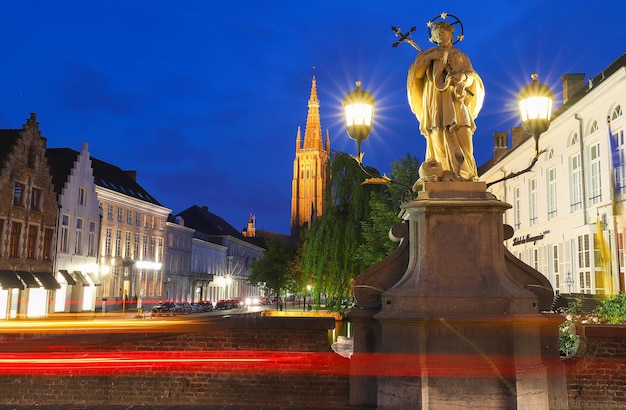 Pintoresco paisaje urbano con un canal de cuento de hadas medieval Puente San Nepomuceno y el muelle Dijver y la Iglesia de Nuestra Señora en Brujas Bélgica