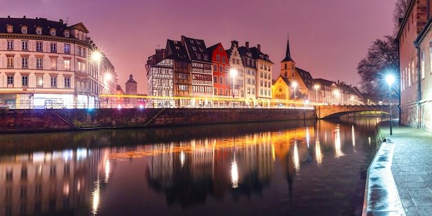 Pintoresco panorama del muelle y la iglesia de San Nicolás con reflejos de espejo en el río Ile durante la hora azul de la mañana, Estrasburgo, Alsacia, Francia