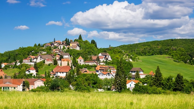 Pintoresco pueblo en un exuberante paisaje de colinas cubiertas de hierba