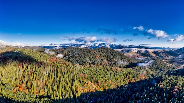 Pintorescos paisajes de montaña de otoño con nieve cerca de la aldea