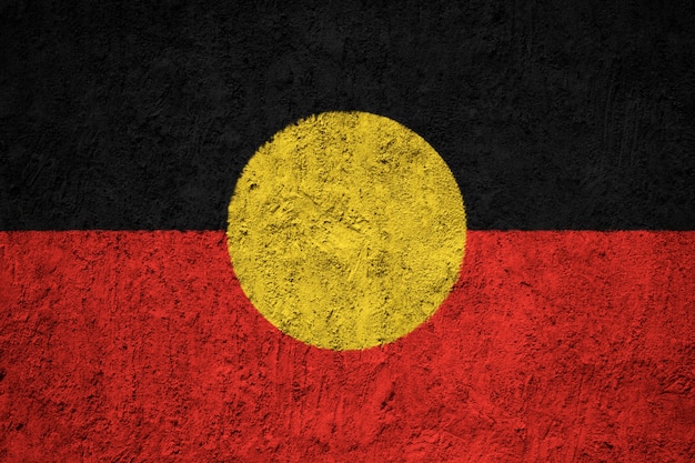 Pintou a bandeira nacional do aborígene australiano em uma parede de concreto