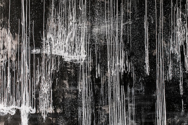 Pintura abstracta: manchas y salpicaduras de pintura blanca sobre un fondo oscuro