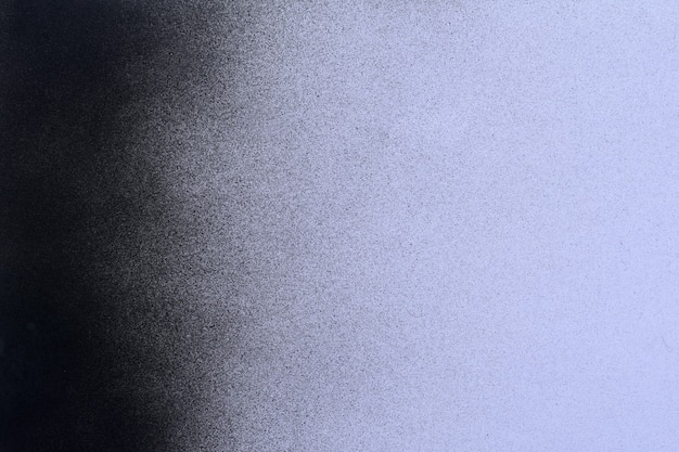 Pintura en aerosol negra sobre un fondo de papel de color lila