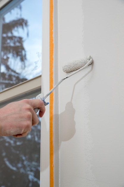 Pintura de apartamento en renovación con sala de rodillos de pintura de color blanco