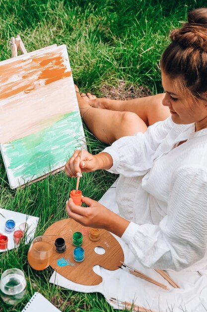 Foto pintura de artista en el caballete al aire libre en el jardín dibujo de taller de arte al aire libre