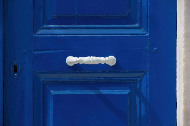 Pintura azul tradicional fondo de puerta cerrada de madera con mango blanco Isla Cícladas espacio griego