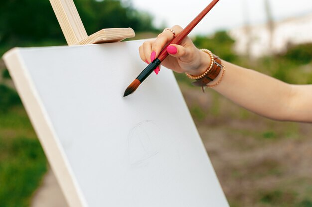 Foto pintura caucásica joven de la mujer en lona afuera