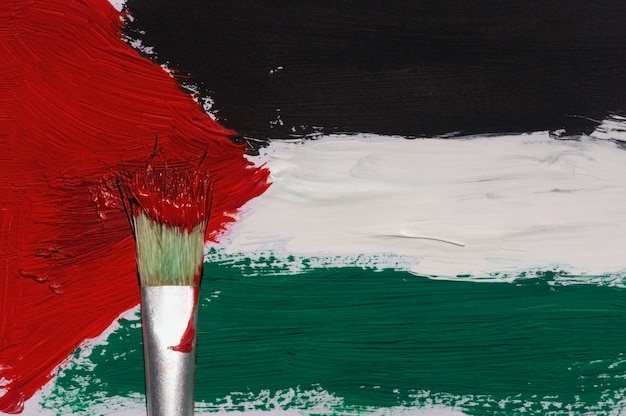 Foto pintura com pincel da bandeira da palestina em um papel para plano de fundo e papel de parede, foco selecionado.