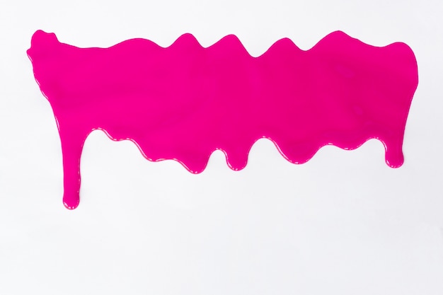 Pintura cor-de-rosa que goteja em um branco.