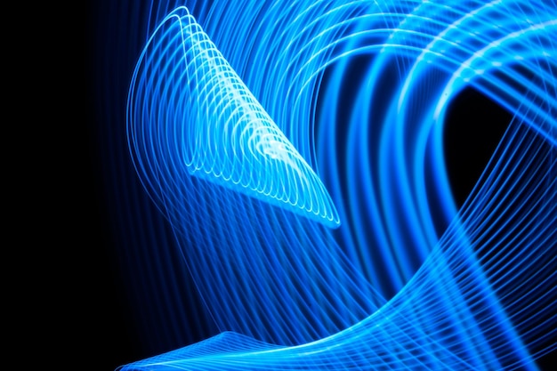 Foto pintura de luz de longa exposição linhas curvas de azul metálico de néon vibrante em fundo preto