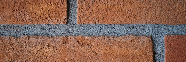 Foto pintura de parede de tijolo vermelho áspero com costuras textura de pedra para construção de papel de parede