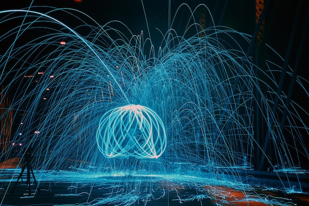 Pintura dinámica de luz de orbe azul con chispas en la noche
