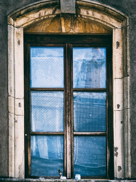 Foto pintura e pincel de pintura na frente de uma velha janela