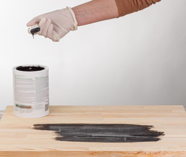 Foto pintura de fondo de madera a mano con pincel y lata de pintura.