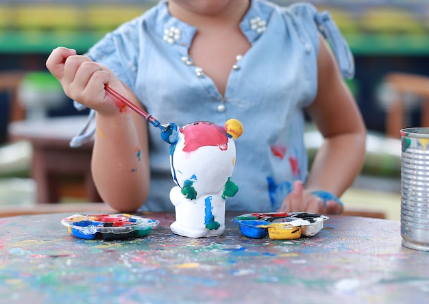 Pintura de la niña del primer en la muñeca del estuco.