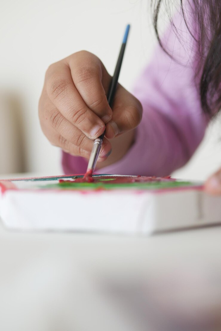 Foto pintura de un niño en un lienzo con pincel en una habitación brillante