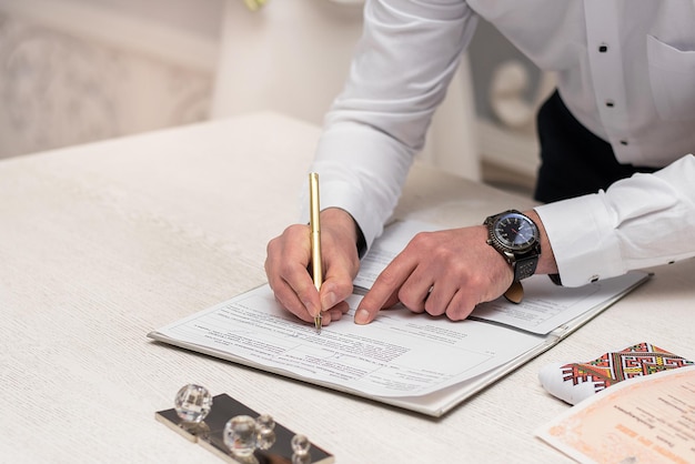 Pintura en la oficina de registro en la ceremonia de boda firmando un documento con un bolígrafo