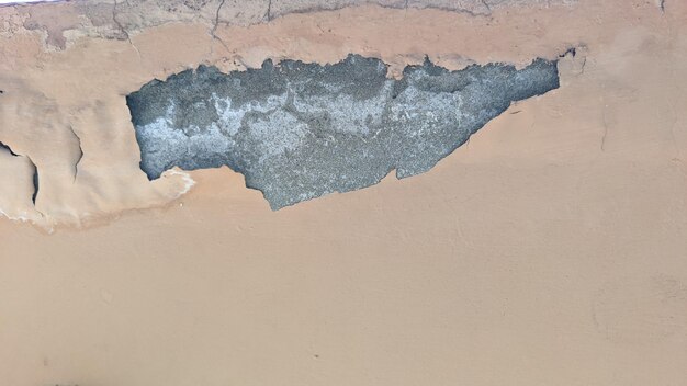 Una pintura de una pared agrietada con una mancha azul y una mancha de pintura blanca.