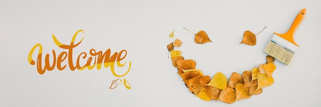 Pintura de pincel con emoji de hojas con una sonrisa concepto creativo de otoño