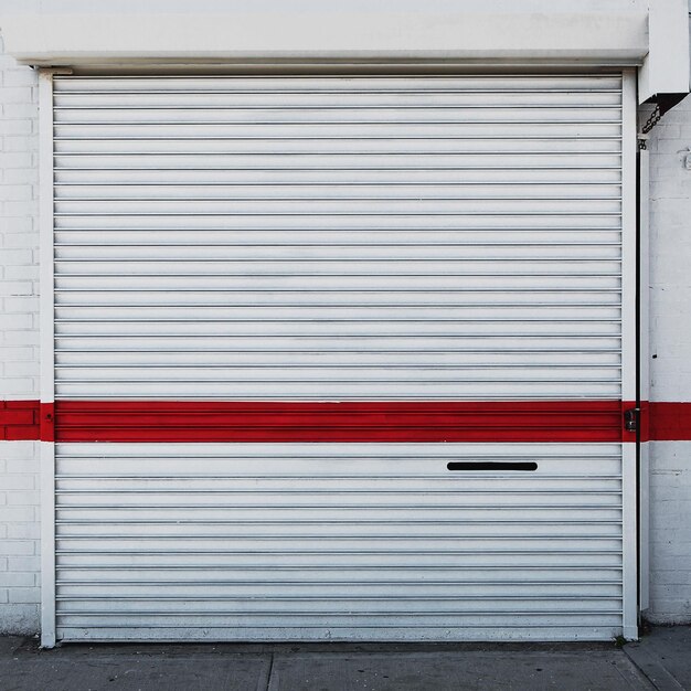 Foto pintura roja en una persiana blanca cerrada