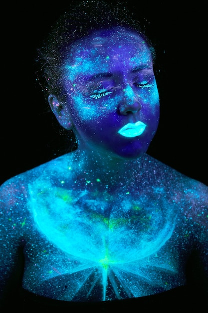 Pintura UV de un universo en un retrato de cuerpo femenino