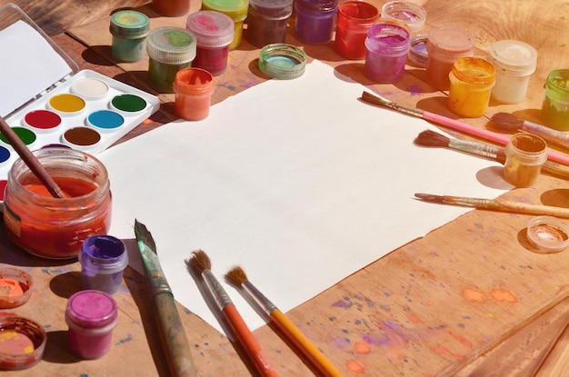 Pinturas e pincéis de aquarela multicoloridos na mesa