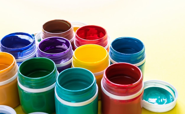 Pinturas de gouache multicolores en frascos en primer plano