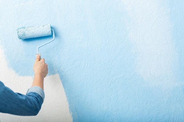 Pinturas de textura de la pared con rodillo en el espacio libre azul