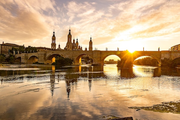 Foto pinturoso pôr-do-sol em um dia de verão na cidade de zaragoza, na espanha, com vista para o rio e a catedral