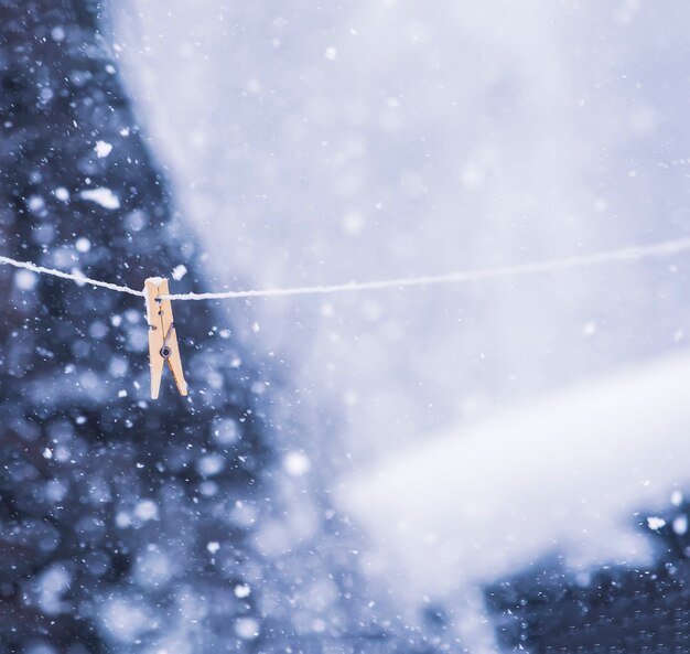 Pinza para la ropa de colores en la cuerda en la tormenta de nieve al aire libre