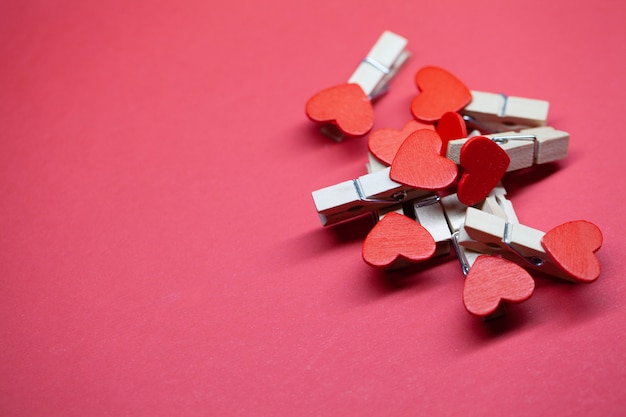 Pinzas decorativas con corazón sobre superficie roja