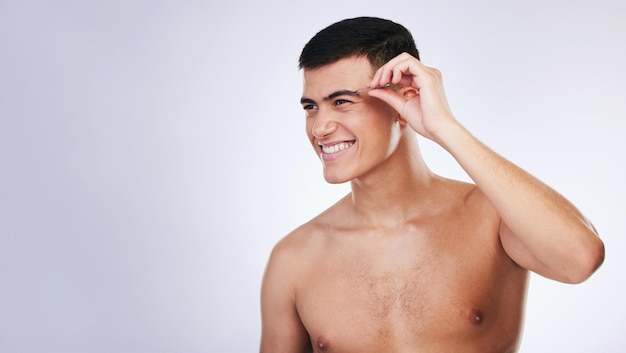 Pinzas para hombre y cuidado de la piel limpio con tratamiento facial y de belleza para el cuidado y el bienestar en el estudio Dermatología modelo masculina y herramienta de depilación para cejas con fondo blanco y espacio de maqueta