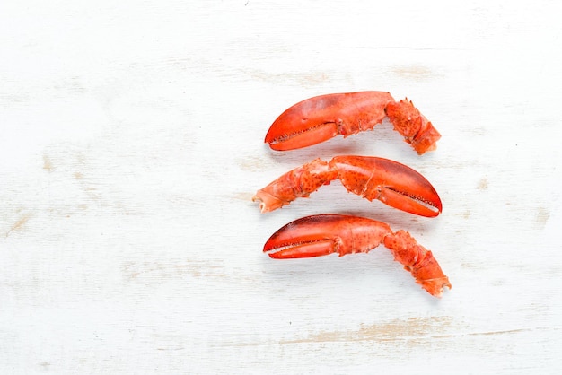 Pinzas de langosta Mariscos sobre un fondo blanco de madera Vista superior Espacio de copia libre