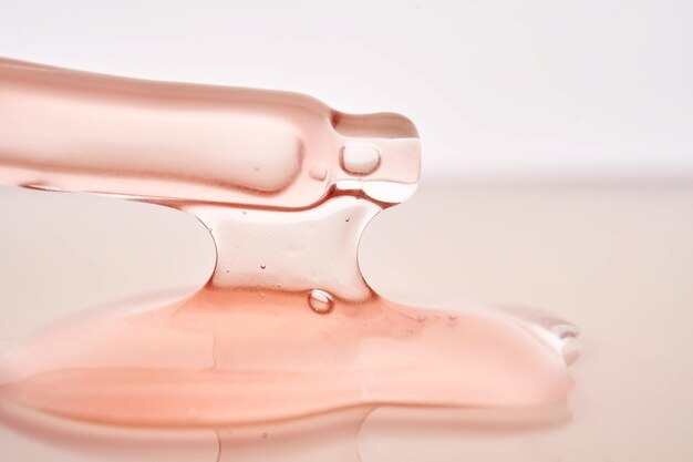 Foto pipeta com um close-up cosmético rosa viscoso