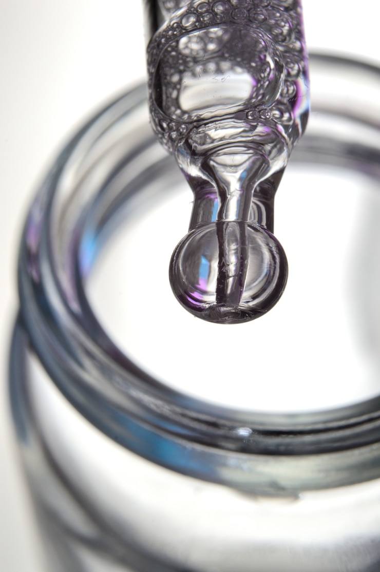 Foto una pipeta cosmética llena de un líquido burbujeante y una botella. de cerca.