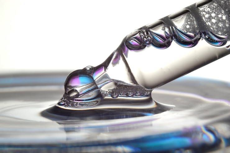 Foto una pipeta cosmética llena de un líquido burbujeante y una botella. de cerca.