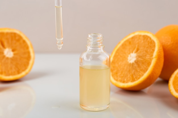 Pipetee con aceite esencial de naranja sobre la botella y las naranjas. Concepto de medicina natural. Aromaterapia