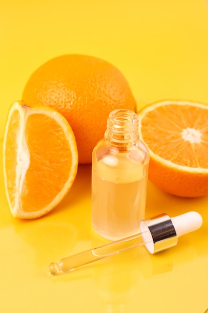 Pipetee con aceite esencial de naranja sobre la botella y las naranjas. Concepto de medicina natural. Aromaterapia