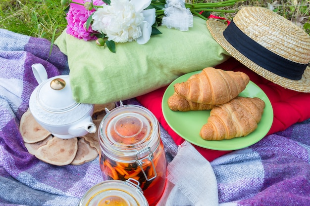 Piquenique ao ar livre com chá e croissants