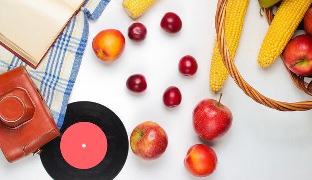 Piquenique do estilo retro francês. cesta com frutas e legumes, câmera retro, livro, baguete e outro fundo branco de comida de piquenique.