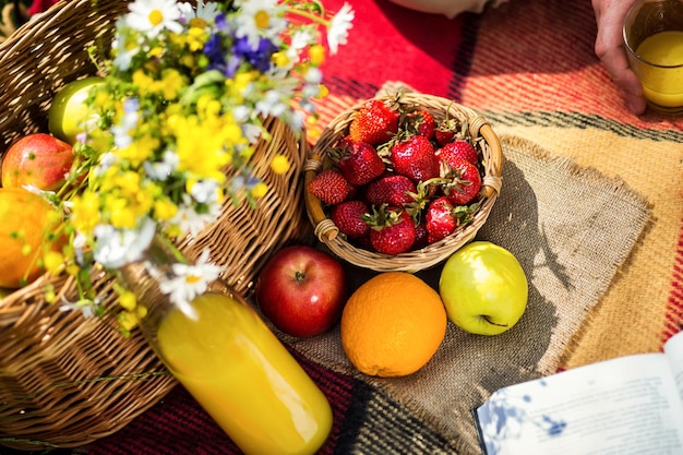 Piquenique no suco de grama um buquê de frutas de flores silvestresPiquenique no parque na gramaAlimentos e acessórios saudáveisPiquenique Grama Summer Time Rest