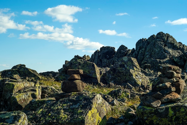 Foto pirâmide de pedra em um belo terreno montanhoso selvagem com rochas pitorescas sob um céu azul