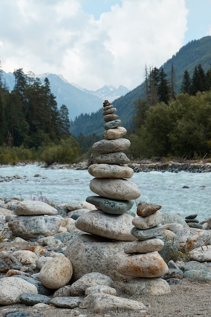 Pirâmide de pedras à beira de um rio de montanha, montanhas e paisagem montanhosa