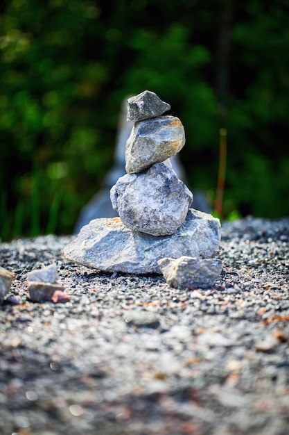 Pirámide hecha de piedras de granito sobre fondo verde de la naturaleza