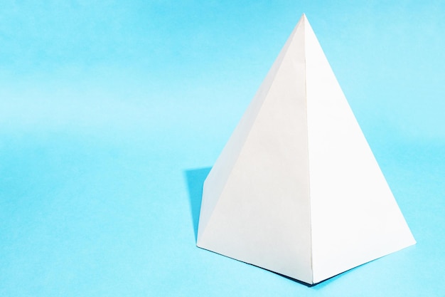 Pirámide hexagonal de papel artesanal sobre turquesa