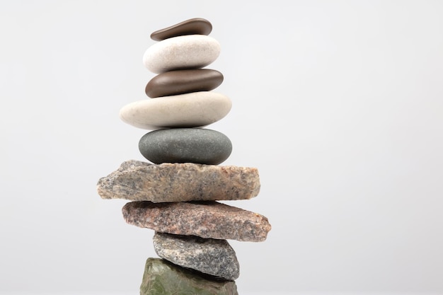 Pirámide de piedras apiladas sobre un fondo claro estabilización y equilibrio en la vida