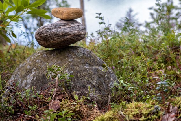 Una pirámide de piedras en el bosque con el telón de fondo de un lago